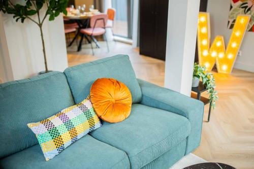 a blue couch with a pillow on it in a living room at Kerkstraat in Hilversum