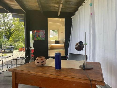 a wooden table with a blue vase on top of it at Graine de Paradis - Tiny House in Le Landeron