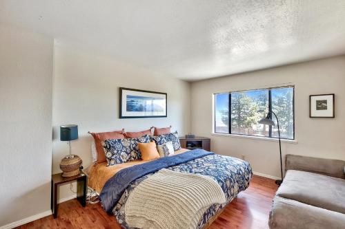 a bedroom with a bed and a couch and a window at MV55 Lakeview townhome on the Ridge with Hot tub in Stateline