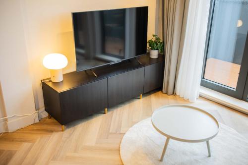 a living room with a tv and a white chair at Kerkstraat in Hilversum