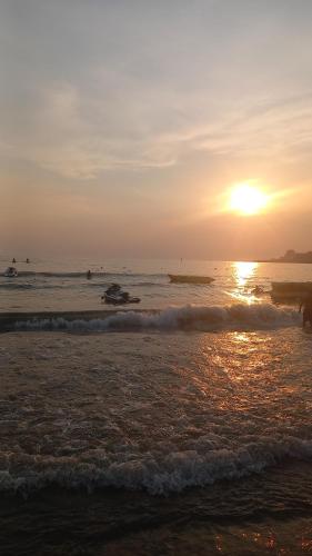 a sunset on a beach with the sun setting at Apartamente Shengjin lisuss beach in Shëngjin