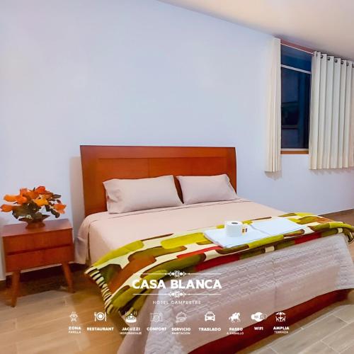 a bedroom with a bed with a table on it at HOTEL HUAYTARA CasaBlanca in Huaytará