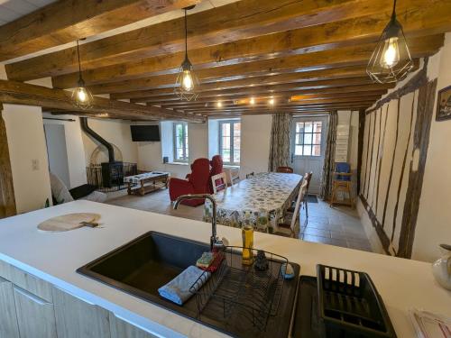 - une cuisine avec un évier et une table dans une chambre dans l'établissement Gîte familial rénové avec jardin, proche forêt d'Orléans et activités, à 1h d'Orléans et 2h de Paris - FR-1-590-439, à Fréville-du-Gâtinais
