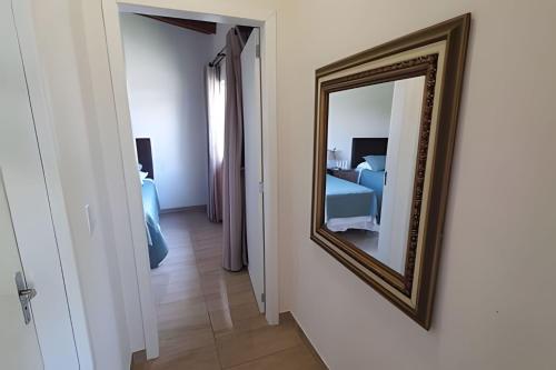 a mirror hanging on a wall next to a bedroom at Aconchego à Beira-Mar em Gov Celso Ramos/SC in Armação