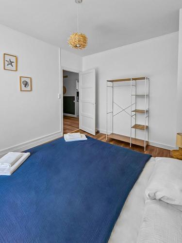 - une chambre avec un grand lit et un tapis bleu dans l'établissement Évasion Paisible au Creusot - T3 rénové et coloré, au Creusot