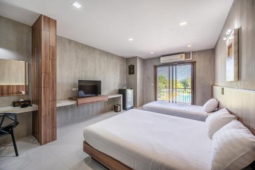 a bedroom with a large bed and a television at Pirom Garden Private Villa in Pattaya North