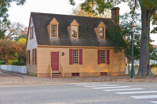 an old house with a red door on a street at Colonial Houses, an official Colonial Williamsburg Hotel in Williamsburg