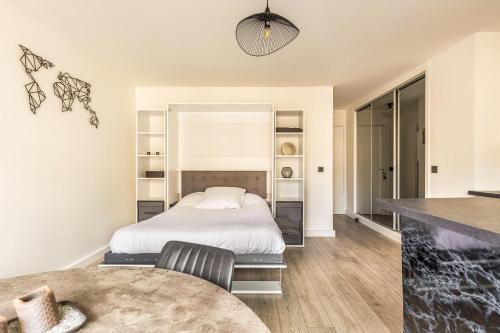 une chambre avec un lit et une table dans l'établissement Charmant studio du 12ème, Parking gratuit et Métro, à Paris