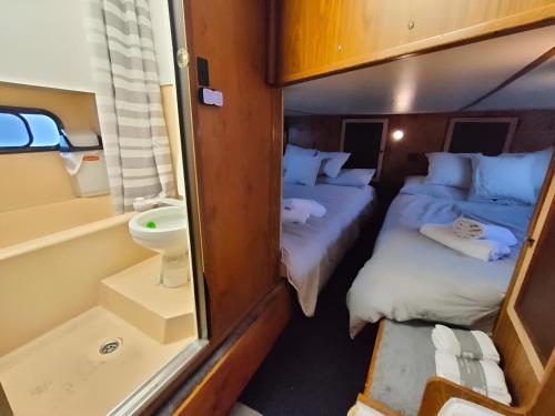 une petite chambre avec deux lits et des toilettes dans l'établissement Barco muy espacioso con dos terrazas Valencia CENTRO!!, à Valence