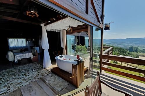a bathroom with a bath tub on a patio at Chalé da Montanha com Ofurô in Santo Amaro da Imperatriz