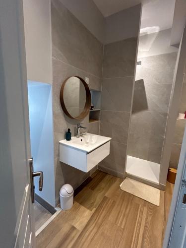 une salle de bain avec un lavabo et un miroir dans l'établissement Villa les Lys 2, à La Seyne-sur-Mer