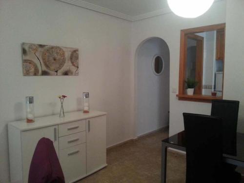 Habitación con armario blanco y espejo. en Zoa Apartment, en Torrevieja