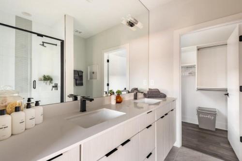 a white bathroom with two sinks and a mirror at Minter Teal with Rooftop Balcony in Charlotte