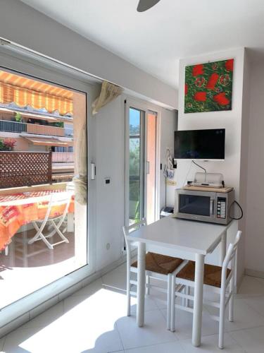 une cuisine avec une table blanche et un four micro-ondes dans l'établissement Relax Au Soleil - Proche de la plage 100 m - Centre-ville, à Menton