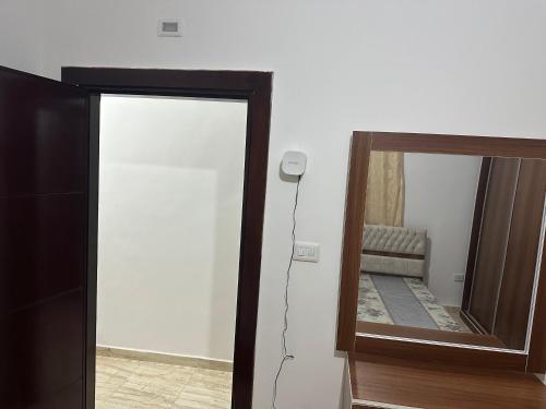 a mirror in a room with a chair in front of it at Airport Road شارع المطار in Al Yādūdah