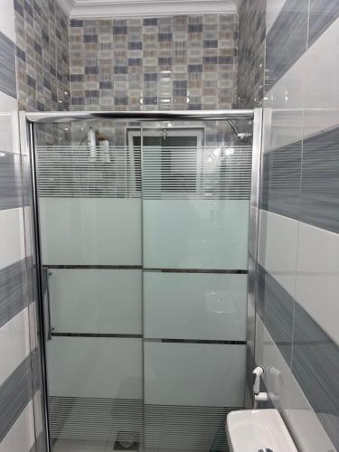 a bathroom with a shower and a toilet and a sink at Airport Road شارع المطار in Al Yādūdah
