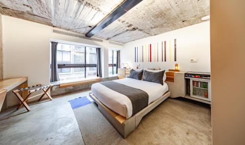 a bedroom with a large bed and some windows at Hotel Carlota in Mexico City