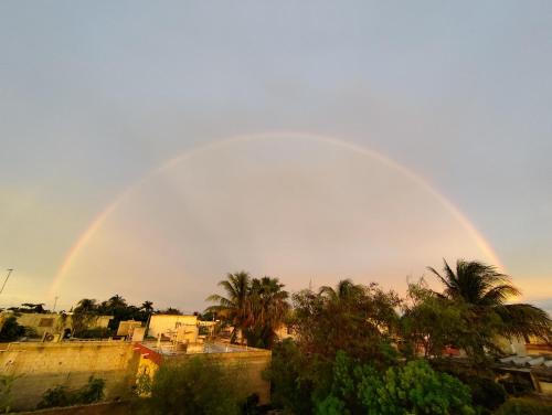 a rainbow in the sky over a city with trees at Casa La Güerita in Progreso