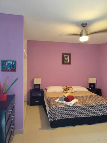 a bedroom with a bed with a purple wall at Casa La Güerita in Progreso
