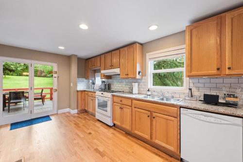 a kitchen with wooden cabinets and a dining room with a table at Private park in a cozy home next to I-90 huge yard in Mercer Island