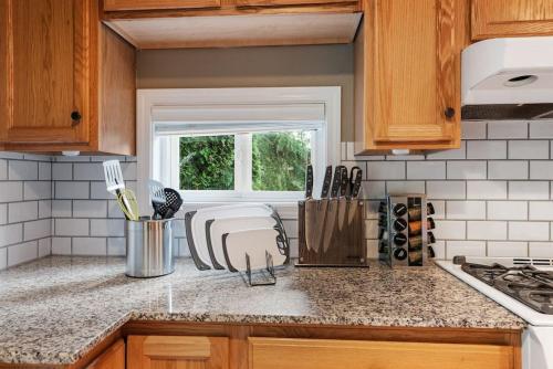 a kitchen with wooden cabinets and a counter top at Private park in a cozy home next to I-90 huge yard in Mercer Island