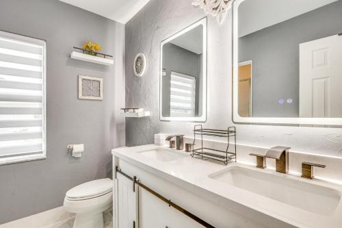 a bathroom with a sink and a toilet and a mirror at Sun-Soaked Pompano Beach Home with Private Pool! in Pompano Beach
