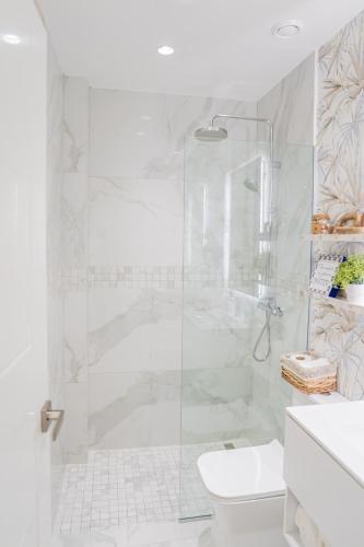 a white bathroom with a shower and a toilet at Xeliter Cana Rock Punta Cana in Punta Cana
