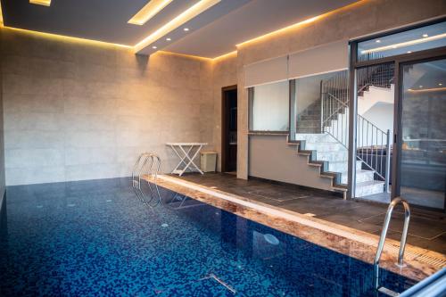 a room with a swimming pool and a staircase at Makanak Villas in Jerash