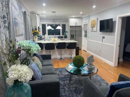 a living room with a couch and a table and a kitchen at Spectacular Boston City View in Boston