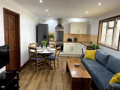 a living room with a blue couch and a table at Garden flat in London in London