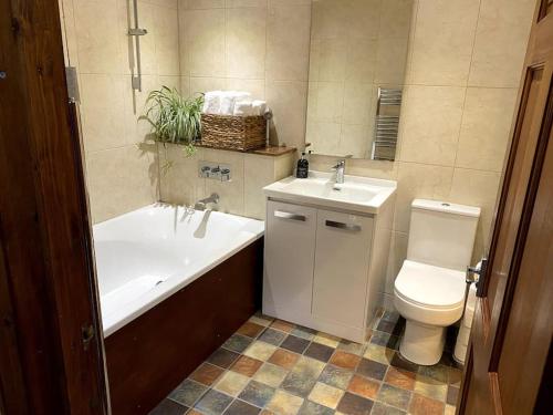 a bathroom with a tub and a toilet and a sink at Garden flat in London in London