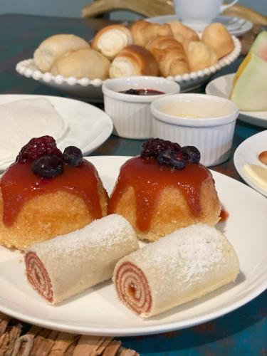 a plate with two slices of bread and blueberries and rolls at Odoiá Maragogi Restaurante e Estalagem in Maragogi