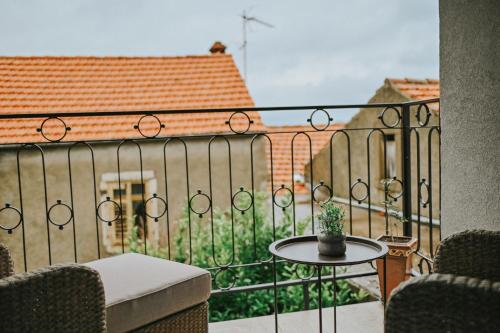 a balcony with a table and a view of a building at Stone House Zrinski entire apartment 62 m2 in Luka