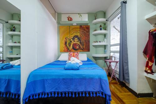 a bedroom with a blue bed and a painting on the wall at Casa Itzae B&B Polanquito Dog Friendly in Mexico City