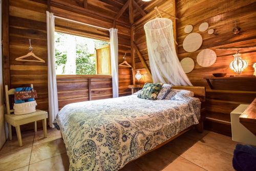 a bedroom with a bed in a log cabin at UP! HOUSE Costa Rica ~ 2 Casitas in Playa Chiquita in Talamanca