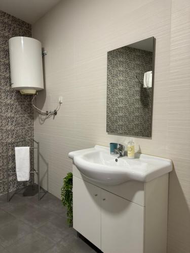a bathroom with a white sink and a mirror at Cube30 Águeda - Alojamento Local 1 in Águeda