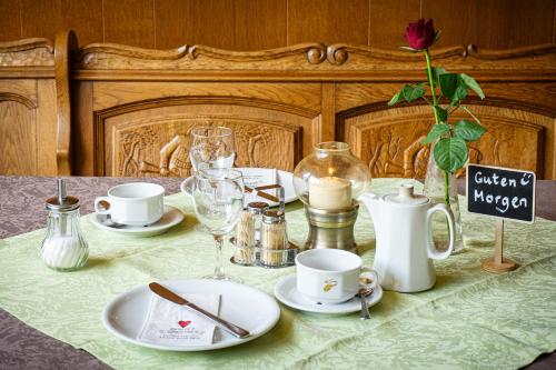 a table with plates and cups on a table with a table cloth at Gasthof Zur Traube in Finkenbach
