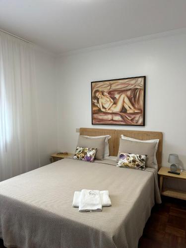 a bedroom with a bed with a towel on it at Guest House MJ in Póvoa de Varzim