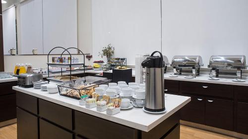 a kitchen with a counter with plates and cups at Staybridge Suites Puebla by IHG in Puebla