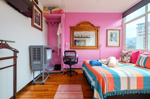 a pink room with a bed and a television at Casa Itzae B&B Polanquito Dog Friendly in Mexico City