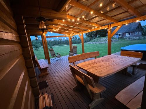 a wooden deck with a wooden table and benches at Escape of city in Pabiržė