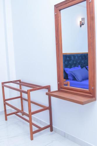 a mirror with a wooden stand next to a shelf at Villa 34 in Ambalangoda