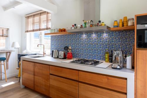 a kitchen with a sink and a stove top oven at Beautifully located dune villa near Noordwijk beach in Noordwijk
