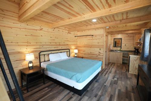 a bedroom with a bed in a log cabin at Pine Haven Lodging in Rockerville