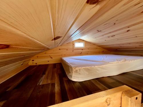 a small bedroom with a bed in a wooden room at Pine Haven Lodging in Rockerville
