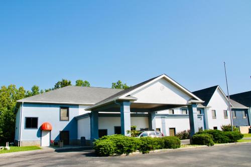 a white and blue house with a car in the driveway at Grand Vista Hotel & Suites in Vonore