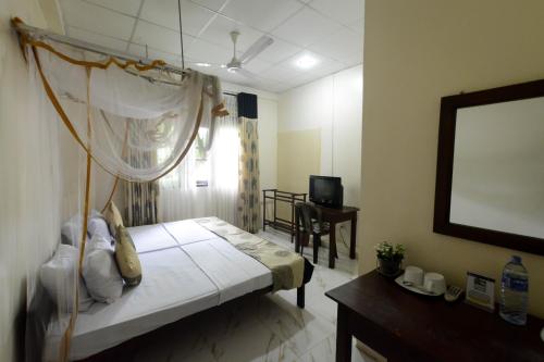 una camera da letto con un letto con zanzariera di Pavana Resort a Embilipitiya