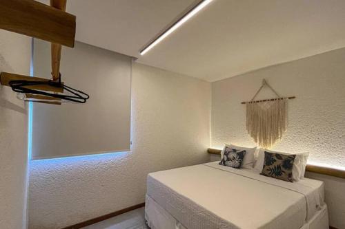 a small bedroom with a bed and a window at Villa Kamby Milagres B003 in São Miguel dos Milagres