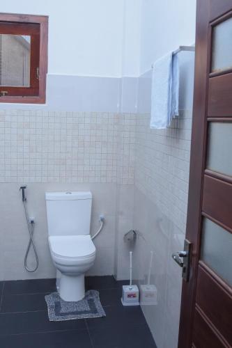 a bathroom with a white toilet in a stall at Villa 34 in Ambalangoda
