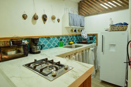 a kitchen with a stove and a refrigerator at MINI UP! Acogedora casita para 2 personas con AC in Cocles